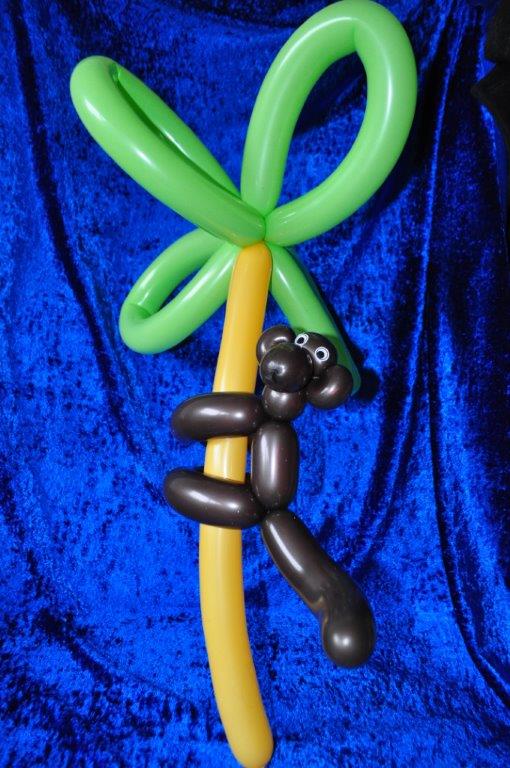 Aus Luftballonkünstler Hände der Affe auf der Palme erfüllt Kinderträume