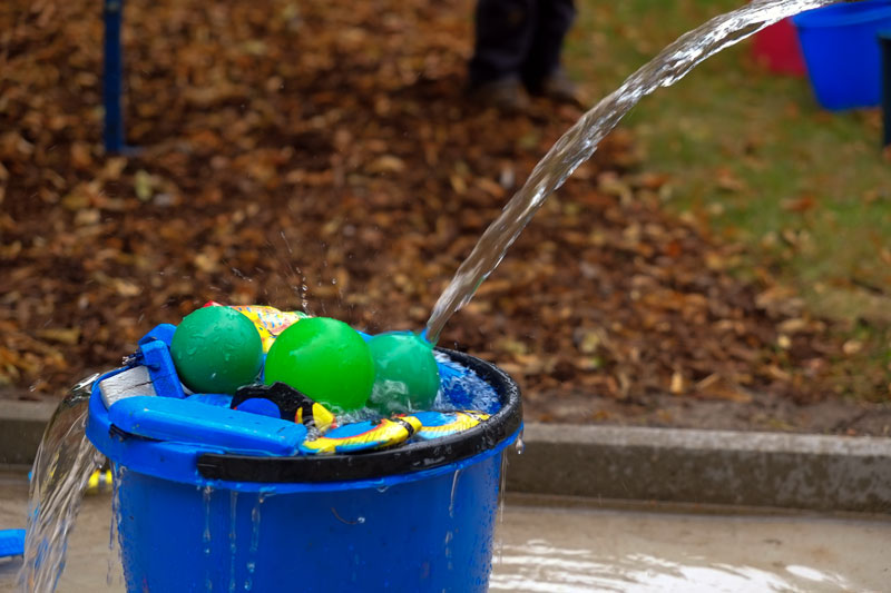 Viele Wassereimer,
 bunte Fische und Bällchengehören als Spielmaterial zur Kinderwerkstatt Spielmobil Wasserbaustelle