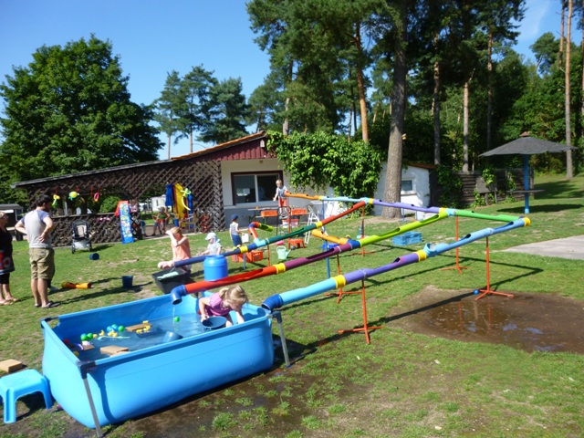 Die Wasserbaustelle der Hula-hoop Kinderwerkstatt aus Osnabrück war im Sommer 2015 für viele Kinderevents ein beliebtes Highlight. Hier sehen Sie die Wasserbaustelle auf einem Campingplatz am Schweriner See in Aktion für die vielen Ferienkinder. Experimentieren mit dem Element Wasser, als Baumeister selbst Rohre verlegen, dabei  kommt auch das Planschvergnügen nicht zu kurz. Die Wasserbaustelle ist eines der vielen Spielmobilangebote der Hula-hoop Kinderwerkstatt Osnabrück. Als kreatives Spielangebot für Kinder lässt sich die Wasserbaustelle für Ferienpassangebote an Grundschulen und auch im  Kindergarten einsetzen. Als sehr beliebt hat sich dieses Angebot auch auf den deutschen Campingplätzen erwiesen.