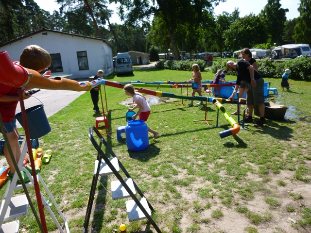 Die Wasserbaustelle der Hula-hoop Kinderwerkstatt aus Osnabrück war im Sommer 2015 für viele Kinderevents ein beliebtes Highlight. Hier sehen Sie die Wasserbaustelle auf einem Campingplatz am Schweriner See in Aktion für die vielen Ferienkinder. Experimentieren mit dem Element Wasser, als Baumeister selbst Rohre verlegen, dabei  kommt auch das Planschvergnügen nicht zu kurz. Die Wasserbaustelle ist eines der vielen Spielmobilangebote der Hula-hoop Kinderwerkstatt Osnabrück. Als kreatives Spielangebot für Kinder lässt sich die Wasserbaustelle für Ferienpassangebote an Grundschulen und auch im  Kindergarten einsetzen. Als sehr beliebt hat sich dieses Angebot auch auf den deutschen Campingplätzen erwiesen.